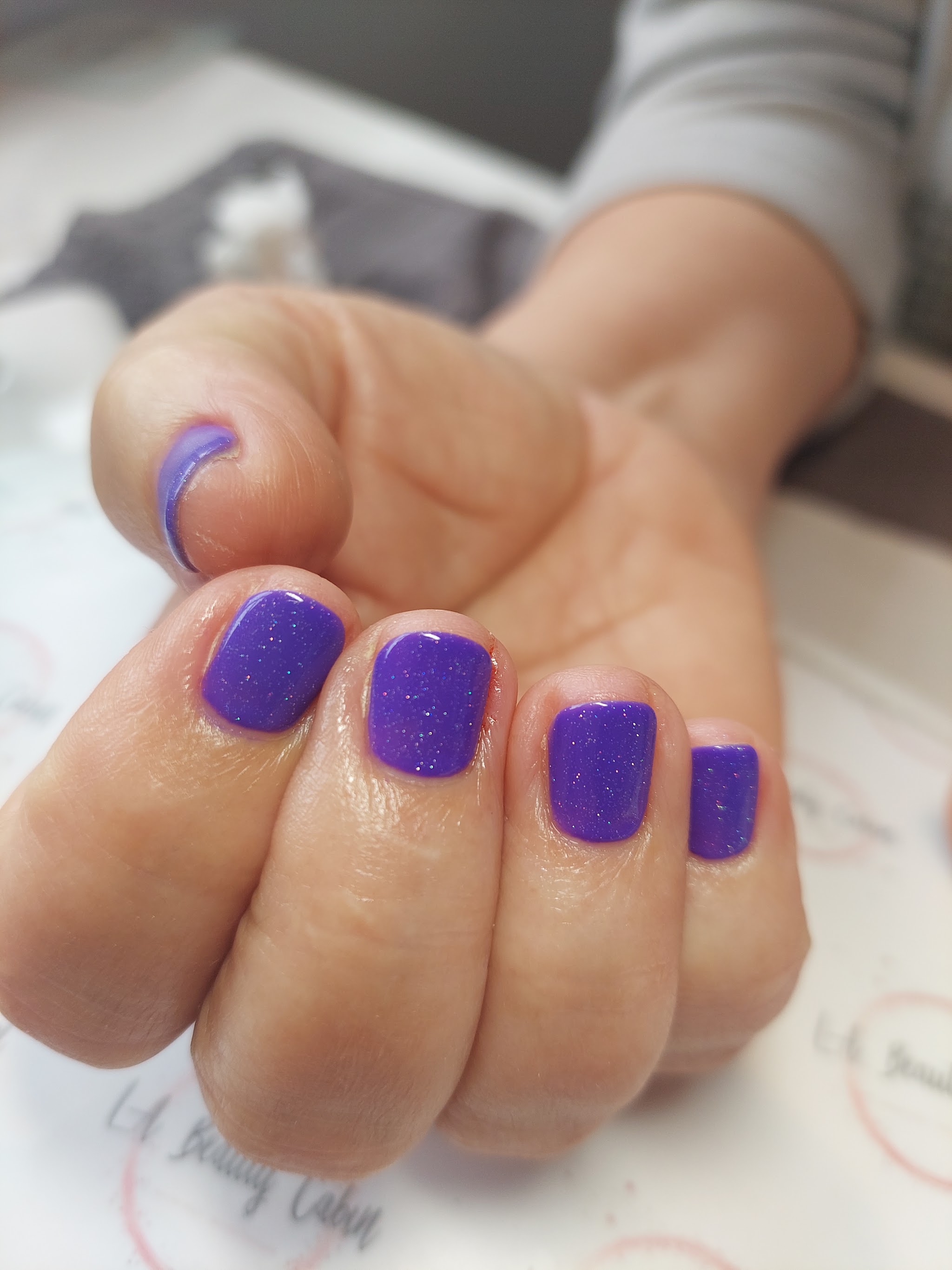 A close view of vivid purple glitter nails